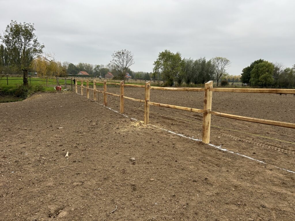 houten omheining met twee horizontale balken voor afbakening akkergrond bij Nieuwlandzicht